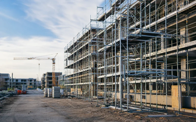 Baustelle mit Gerüst und Kran im Abendlicht